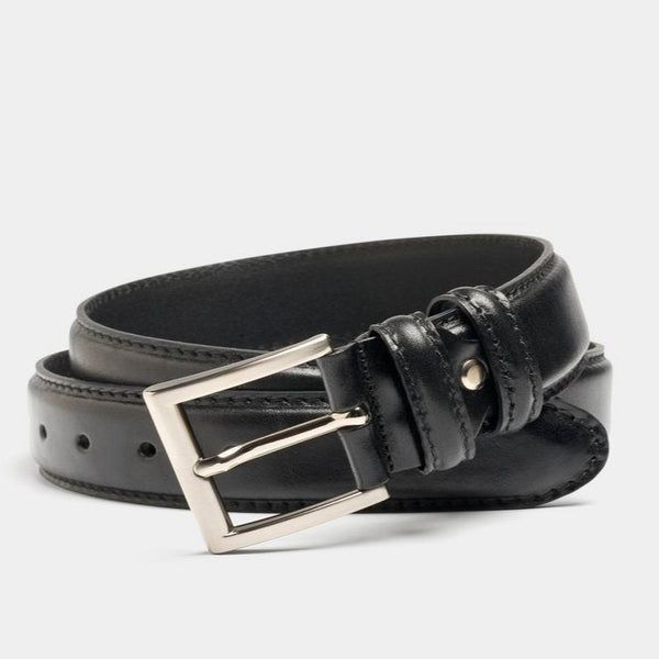 Black leather belt with silver buckle on a light gray background