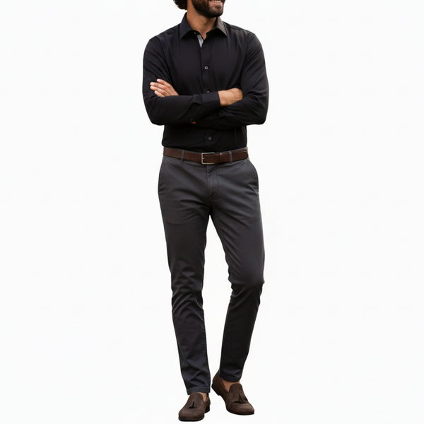 Man wearing a black shirt, gray pants, and brown shoes on a white background